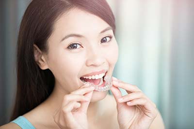 woman smiling with her new Invisalign clear aligners