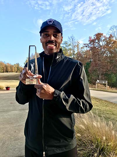 Dr. Daniel Hines holding his golf trophy